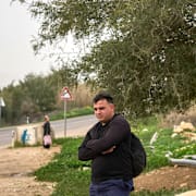 En palestinsk man väntar på bussen på Västbanken den 9 februari 2026. 