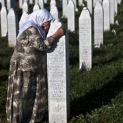 Kvinna sörjer vid gravstenarna i Srebrenica.