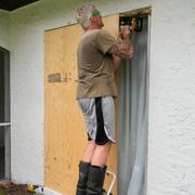 Michael Mims i Fort Myers spikar för dörrar och fönster på sitt hus inför orkanen Miltons ankomst. 