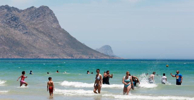 Folk njuter på stranden nära Kapstaden. 21 december 2021.  Nardus Engelbrecht / AP