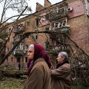 Kyivbor utanför bombad byggnad.