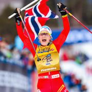 Therese Johaug med den norska flaggan vid målgången. 