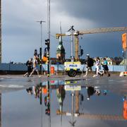 Människor i regn vid Slussen i Stockholm.