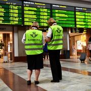 SJ-personal vid en informationstavla på Centralstationen i Stockholm. 