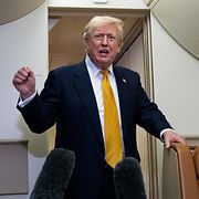 President Donald Trump talar med reportrar efter ett kort stopp på militärflygplatsen i Suffolk i Storbritannien.