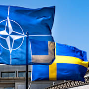 En Natoflagga och en svensk flagga. 