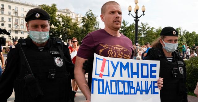Rysk polis griper en oppositionell man som bär ett plakat med texten ”smart röstning”.  Alexander Zemlianichenko / TT NYHETSBYRÅN