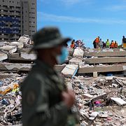 Personer ur Venezuelas nationalgarde intill ett raserat hus i Catia La Mar.