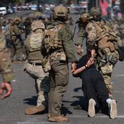 Polis griper en man under protesterna. 