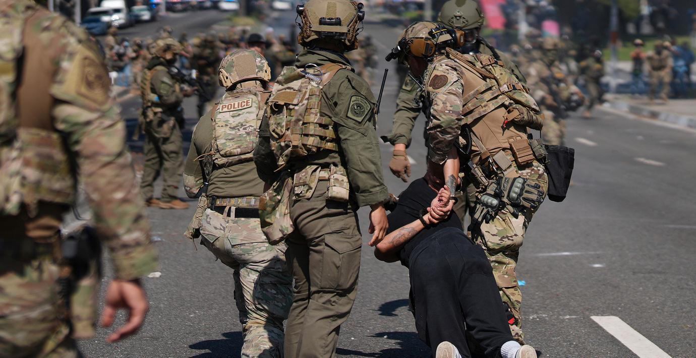 Polis griper en man under protesterna. 