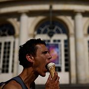 En man svalkar sig med en glass i franske Rennes, sommaren 2025. Denna sommare kan bli ännu varmare.