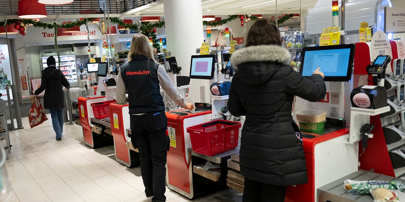 Människor betalar i en snabbköpskassa.