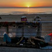 Män sover i närheten av stranden efter att ha flytt israels attacker mot Libanon.