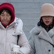 En äldre och en yngre kvinna i ett shoppingområde i Peking.