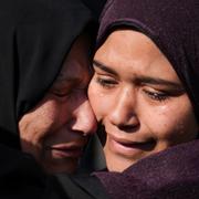 Palestinska kvinnor gråter och kramas efter att deras anhörig dödats i ett bombanfall.