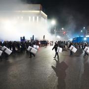 Kravallpolis på väg mot demonstranter i staden Almaty.