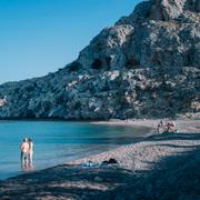 Turister badar i Medelhavet i närheten av ett hotell på Rhodos.