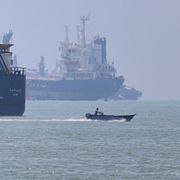 A small motorboat passes anchored vessels in the Strait of Hormuz off Bandar Abbas, Iran, Wednesday, June 17, 2026.(Amirhosein Khorgooi/ISNA via AP)  XEM113