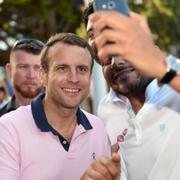 Frankrikes president Emmanuel Macron poserar för en selfie med en man i Le Touquet i norra Frankrike.  