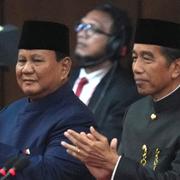 Indonesiens nye president Prabowo Subianto, till vänster, och hans företrädare Joko Widodo applåderar under dagens formella överlämnande av makten. 