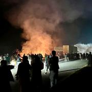 Demonstranter bränner buskar, enligt uppgift för att motverka effekten av polisens tårgasgranater, vid en infart till Islamabad under natten mot måndag. 