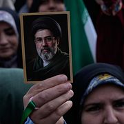 En kvinna hålle Mojtaba Khameneis porträtt.