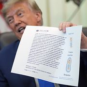 USA:s president Donald Trump håller upp ett inlägg som han själv skrivit på Truth Social.