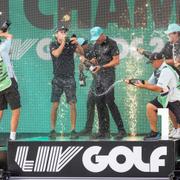 Torque GC:s David Puig, Sebastián Muñoz, Mito Pereira, lagkapten Joaquín Niemann och deras caddies firar på scen med lagtrofén under LIV Golf DC på Trump National Golf Club i Sterling, Virginia, söndagen den 28 maj 2023. 