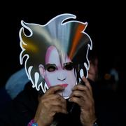 Ett fan med en mask tittar på The Cure under en festival i Mexico City 2023. 