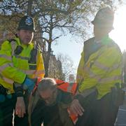 Brittisk polis bär bort en demonstrant från Just stop oil. Arkivbild. 