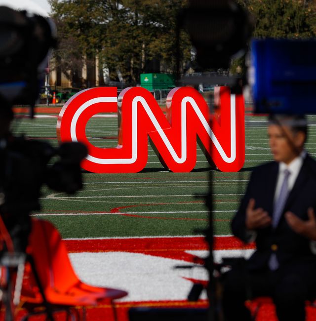 A journalist records video near a CNN sign on an athletic field in Westerville, Ohio, Oct. 14, 2019.  John Minchillo / AP
