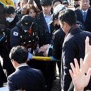 Lee Jae-Myung bär iväg på en bår kort efter attacken.
