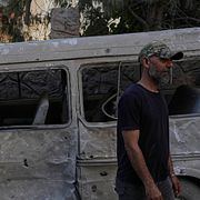 En man framför en förstörd minibus i Beirut i Libanon.