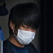 Tetsuya Yamagami eskorteras ut ur polisstationen i Nara 2022. 