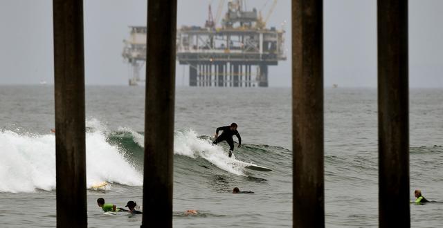 Illustrationsbild. Surfare framför oljerigg i Kalifornien. MARK RALSTON / AFP