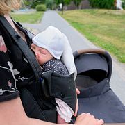 En nyfödd bebis i bärsele. Personerna på bilden har ingen koppling till innehållet i artikeln.
