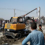Människor tittar på resterna av den skola som träffades i Minab i Iran under krigets första dag.
