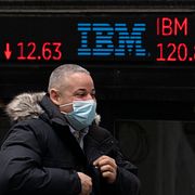 Man går förbi skärm med IBM:s aktiekurs utanför New York-börsen. Arkivbild.