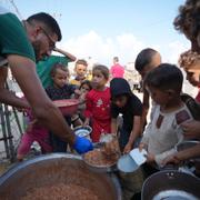 Palestinska barn väntar på att få mat i flyktinglägret Deir al-Balah i Gaza. 18 oktober.