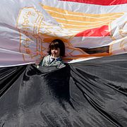 En ung flicka står invirad i en egyptisk flagga när palestinier samlas i Gaza city efter beskedet att Hamas och Fatah är överens om försoning mellan styrena på Gaza och Västbanken.