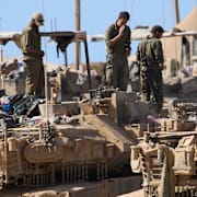 Israeliska soldater jobbar på sina stridsvagnar i södra Gaza.