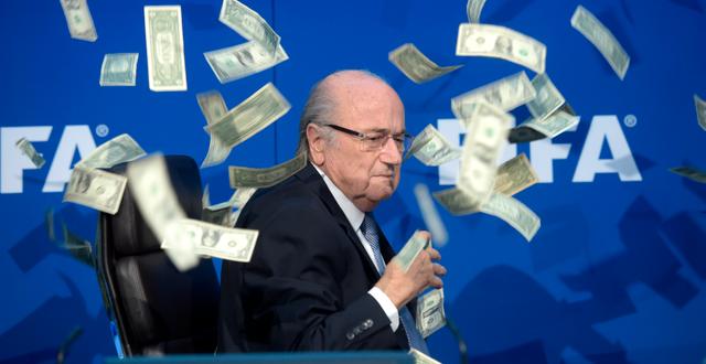 Under en presskonferens den 20 juli 2015 kastade en brittisk komiker dollarsedlar på Sepp Blatter, som fick sparken från FIFA efter korruptionsanklagelser. Ennio Leanza / AP