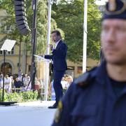 Ulf Kristersson och en polis.