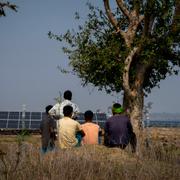 Farmers whose agriculture lands had been transfered to build a solar power plant look at the plant in Mikir Bamuni village, Nagaon district, northeastern Assam state, India, Feb. 18, 2022. 