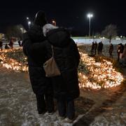 Människor tänder ljus vid minnesplatsen i Örebro.