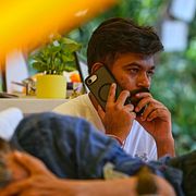 Kackerlackspartiets grundare Abhijeet Dipke talar i telefon bredvid den hungerstrejkande aktivisten Sonam Wangchuk.