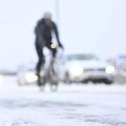 Cyklister och bilar i samband med säsongens första snö i Stockholm i slutet av november. 