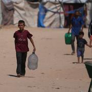 Palestinier bär på vatten i ett flyktingläger i Gaza. 