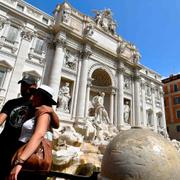 Turister tar selfies vid Fontana di Trevi.