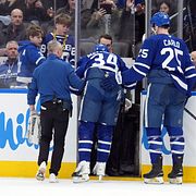 Auston Matthews får hjälp att komma av isen.